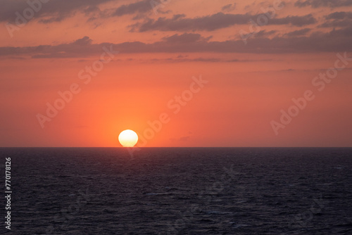 Beautiful sunset sky over the calm ocean. View from the sailing ship. © Mariusz