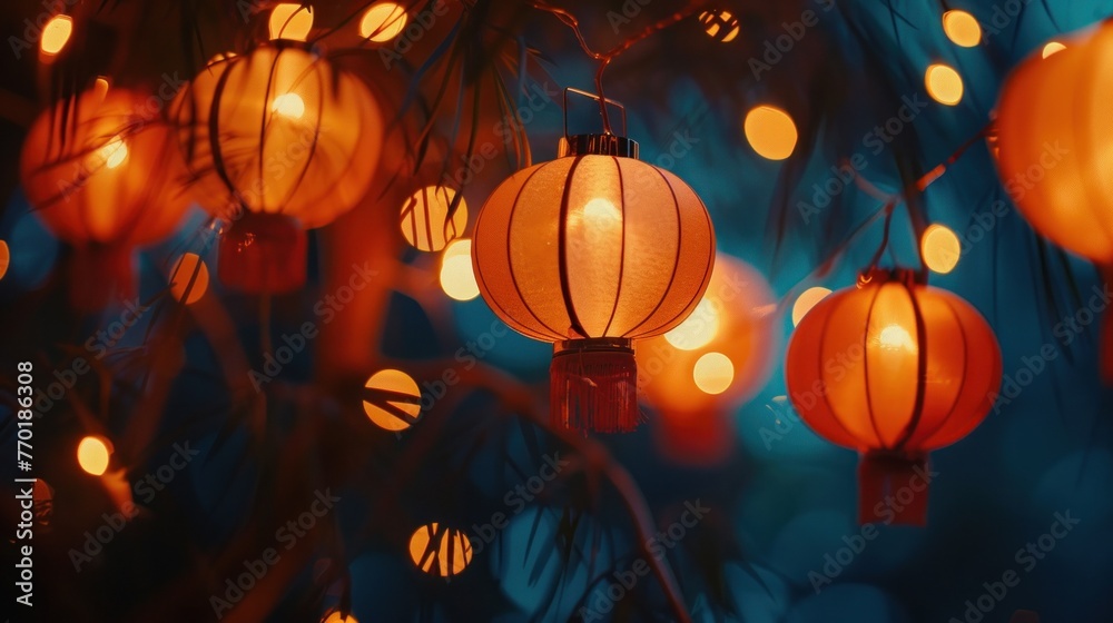 Festive red lanterns glowing amidst backdrop of blue lights and green foliage. Chinese New Year celebration.