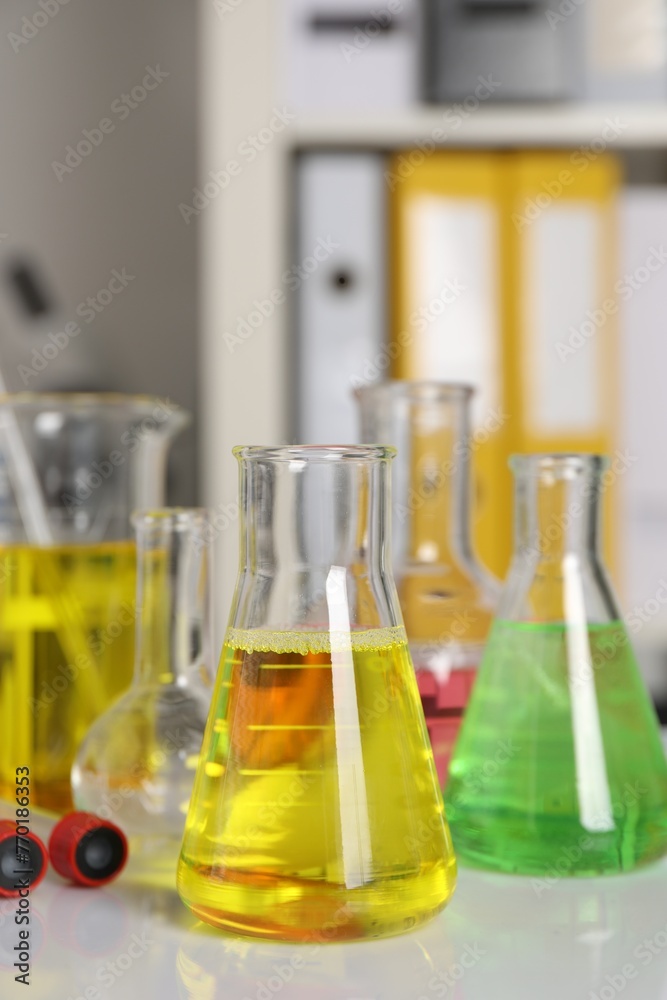 Laboratory analysis. Different glassware with liquids on white table indoors Laboratory analysis. Different glassware with liquids on white table indoors