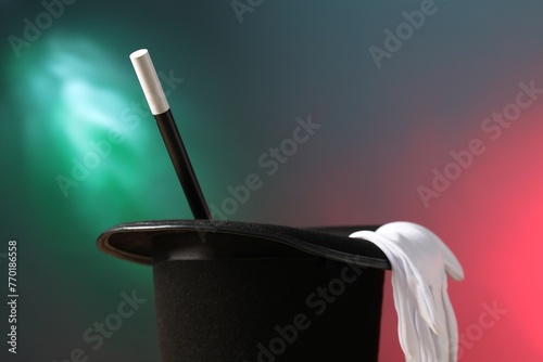Magician's hat, wand and gloves on color background, space for text