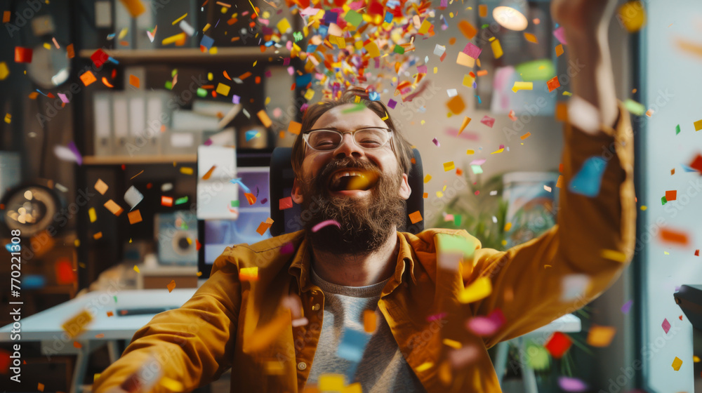 Happy guy in an office environment, sitting in front of a computer blowing confetti on his female colleague Happy guy in an office environment, sitting in front of a computer blowing confetti on his female colleague