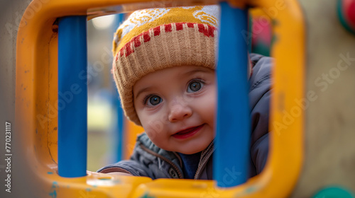 Happy Baby in Knitted Hat Smiling Behind Bars
