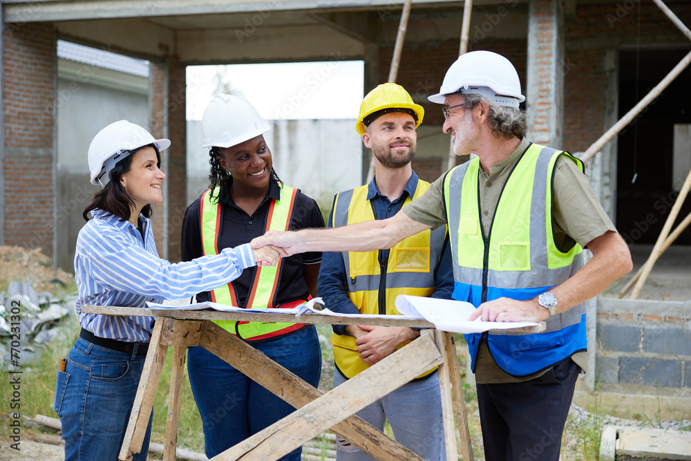 group of workers or architects meeting and shaking hands at construction site group of workers or architects meeting and shaking hands at construction site