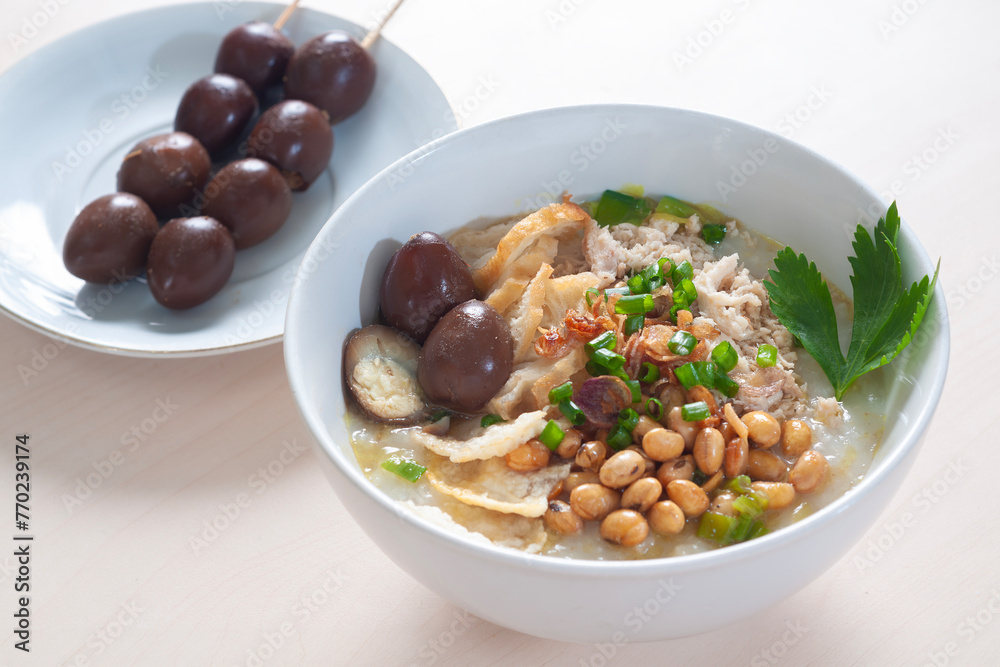 Bubur Ayam Spesial contains white rice porridge with side dishes of fried chicken slices Bubur Ayam Spesial contains white rice porridge with side dishes of fried chicken slices