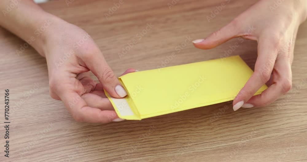 Woman worker sticks out dollar bills from envelope Woman worker sticks out dollar bills from envelope