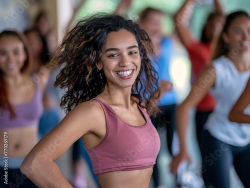 A cheerful young woman in sportswear confidently standing at the forefront of a fitness class.