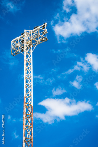 The light tower with partly rusty, sky background, partly cloudy