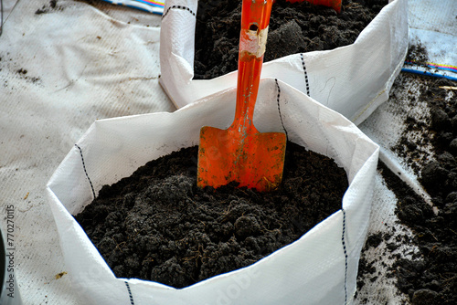 Planting bag with soil and a shovel inside