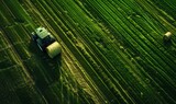 Aerial view on the tractor working on the large wheat field.