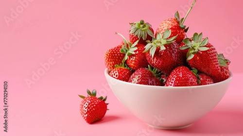 Ripe strawberries in a bowl on a pink background, juicy berries, vitamins.