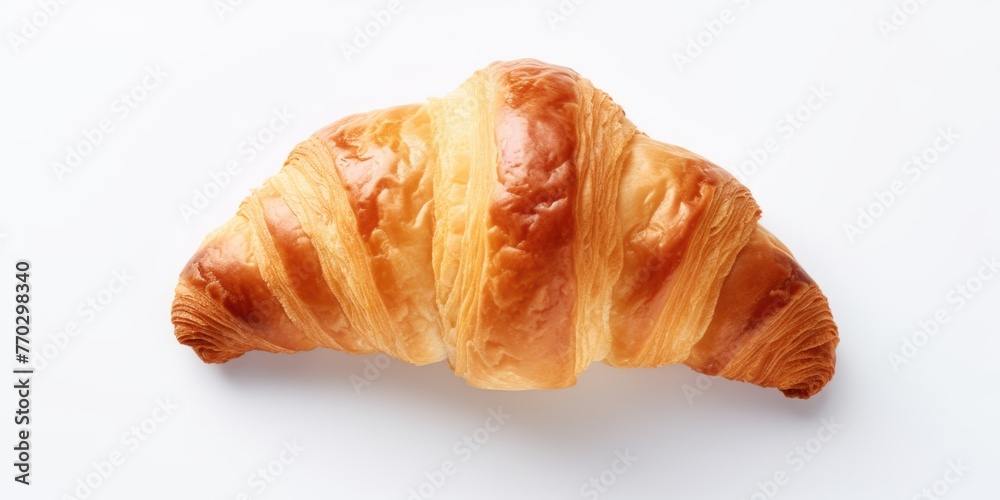 A croissant is sitting on a white background. The croissant is golden brown and has a slightly crispy texture A croissant is sitting on a white background. The croissant is golden brown and has a slightly crispy texture