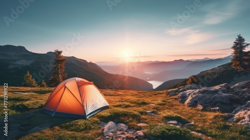 A red tent is set up in a grassy field with a beautiful sunset in the background. Concept of peace and tranquility, as the tent is situated in a serene and picturesque location