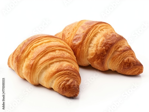 Two croissants are sitting on a white background. The croissants are golden brown and appear to be freshly baked