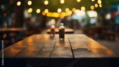 A wooden table with two bottles on it. The table is in a restaurant with a lot of people photo