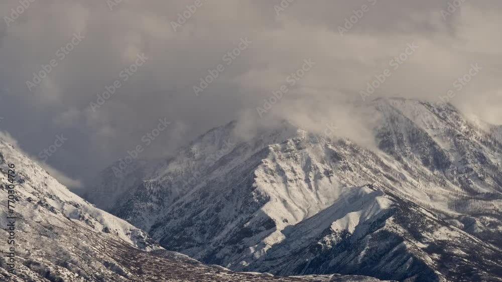 Timelapse of clouds blowing up snow capped Bald Mountain in Santaquin Utah.