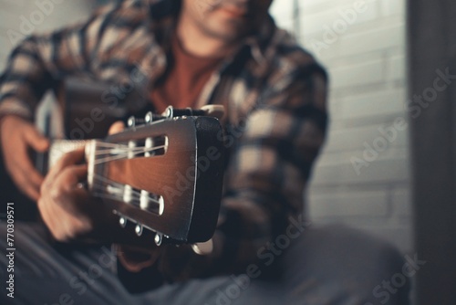 man practicing acoustic guitar at home © Rodrigo