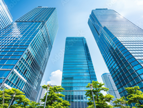 Three tall buildings with a clear blue sky in the background. The buildings are very tall and have a lot of windows