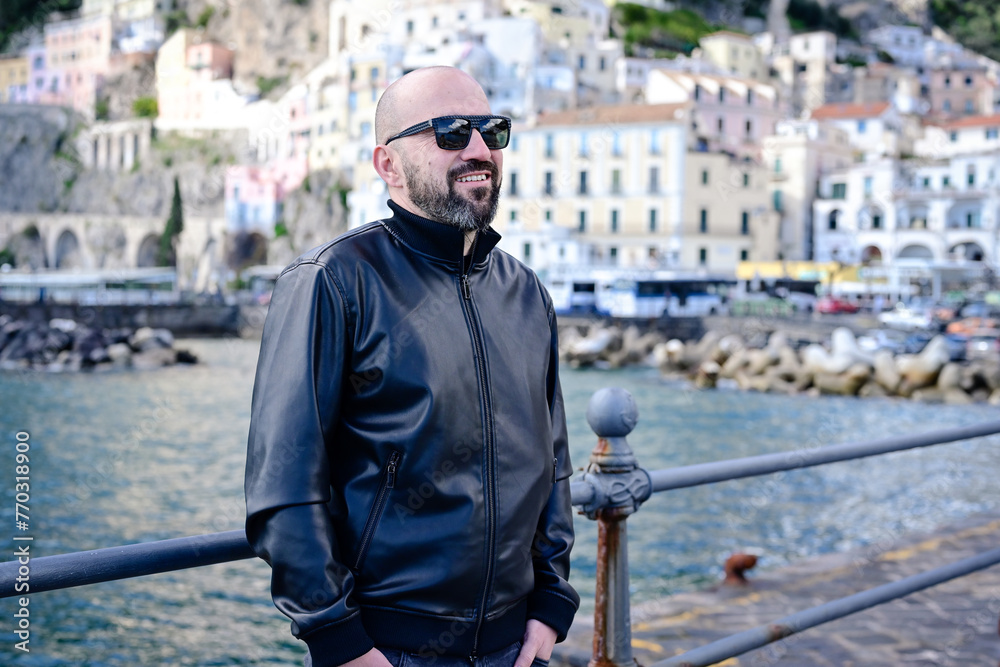 Happy smiling bearded man in front of of Amalfi , Italy. Concept Italian travel trip. Happy smiling bearded man in front of of Amalfi , Italy. Concept Italian travel trip.