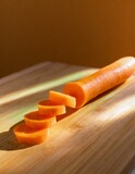 A carrot with its rich orange hue, cut into thin sticks, arranged neatly on a bamboo cutting board, showcasing its crisp texture.