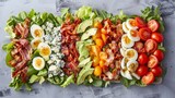 Freshly chopped vegetables and salad ingredients neatly arranged on a grey background including tomato, egg, cheese, avocado, and bacon