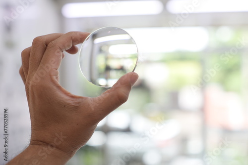 person holding a glasses lens