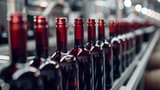 Line of bottling of red wine bottles on clean light factory with closeup view on the alcoholic drink bottle