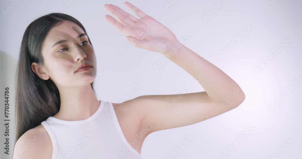 A young woman is worried about her face being exposed to bright sunlight during the day.