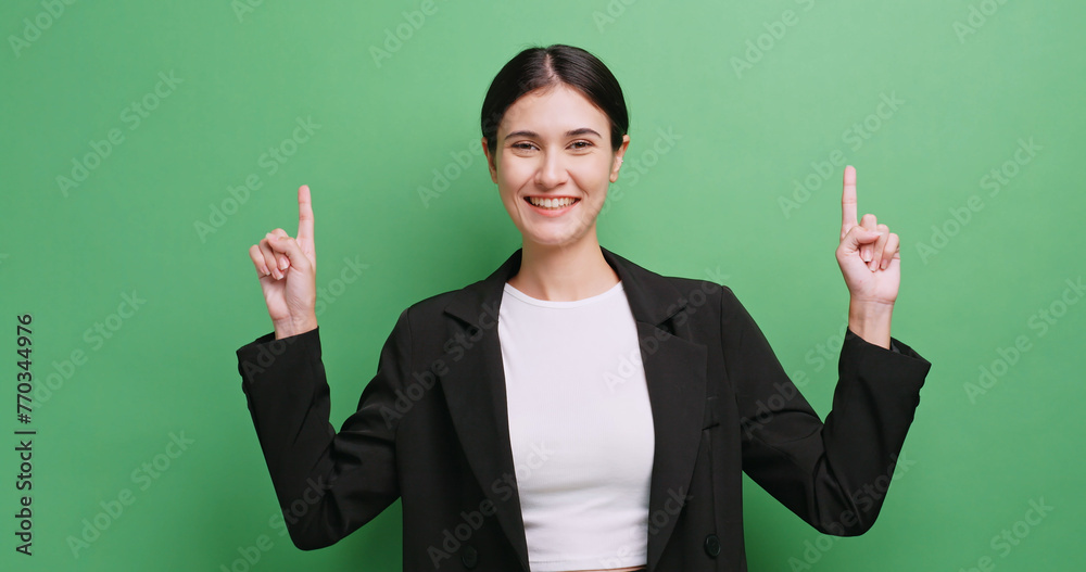 Happy young business woman showing something or copy space for product or sign text. Isolated on green background in studio. Happy young business woman showing something or copy space for product or sign text. Isolated on green background in studio.