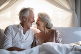 An elderly man and woman, a couple in love, are laying side by side in bed, showing affection and companionship