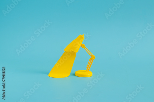 Still life yellow desk lamp against a bright blue background photo