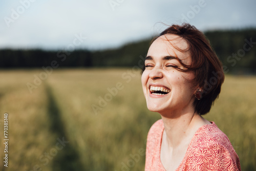 Portrait of a happy girl laughing in a field photo