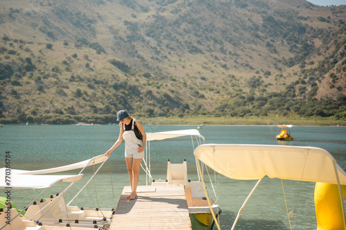 Young woman on dock getting onto pedal boat on Lake Kournas in Crete photo