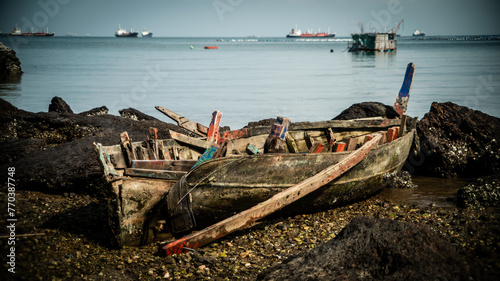 The wreckage of a local fishing boat is stuck in the rocks on the coast of the Gulf of Thailand.