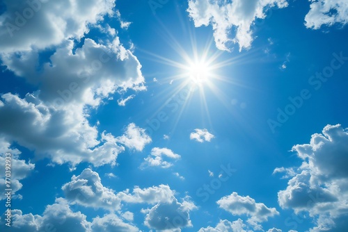 Blue sky background with tiny clouds, sun and the rays of the sun