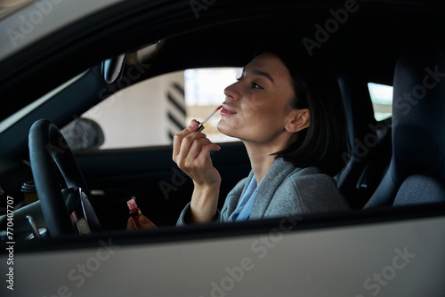 Charming pretty woman driver applying make up