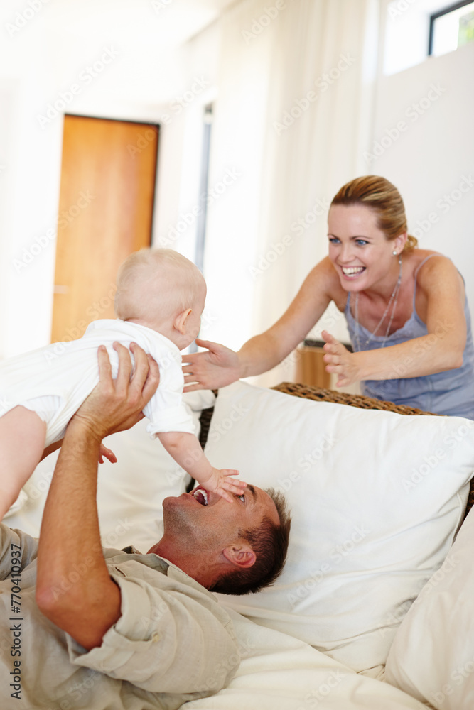 Obraz premium Funny, happy family and play with baby on sofa in home for love, care or father bonding together with mother. Dad, kid and cute infant in living room for connection, smile or parents laugh with child