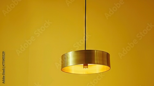 a hanging brass pendant lamp, yellow background, product photo 