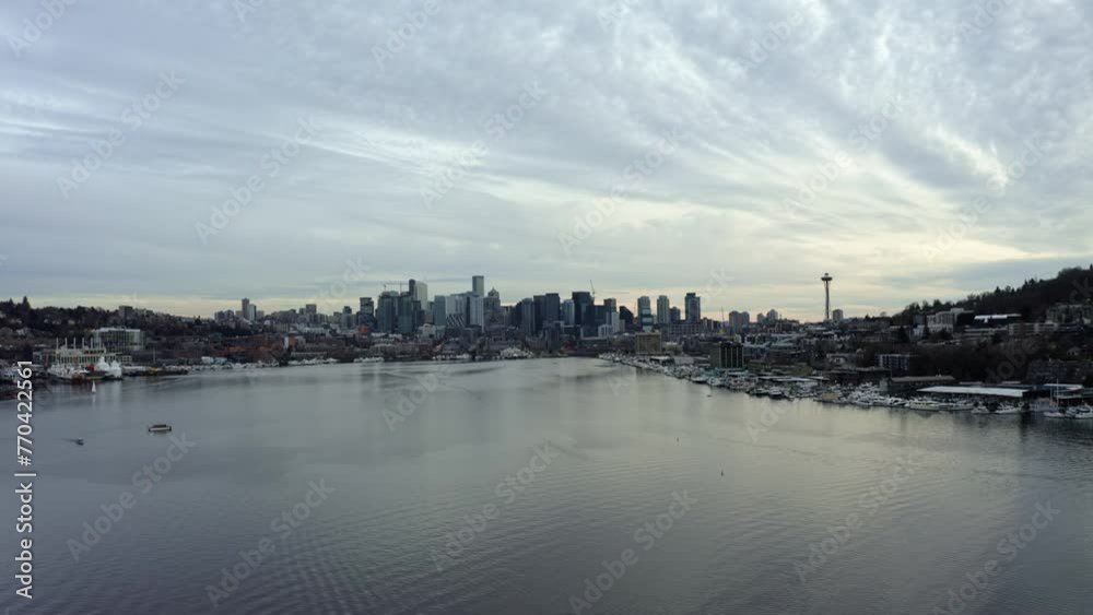 Descending aerial drone shot of the Seattle city skyline with skyscrapers, the space needle and Lake Union from the famous tourist destination, Gas Works Park on an overcast spring evening Descending aerial drone shot of the Seattle city skyline with skyscrapers, the space needle and Lake Union from the famous tourist destination, Gas Works Park on an overcast spring evening
