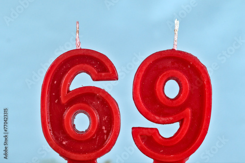 close up on a red number sixty nine birthday candle on a white background.
 photo
