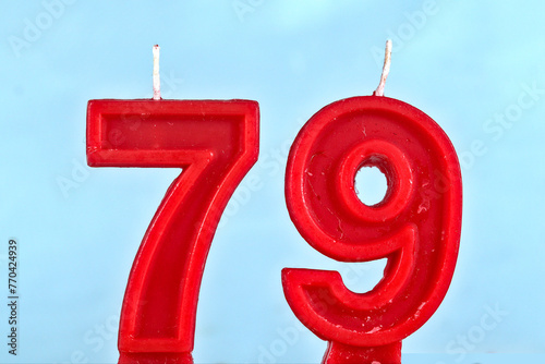 close up on a red number seventy ninth birthday candle on a white background.
 photo