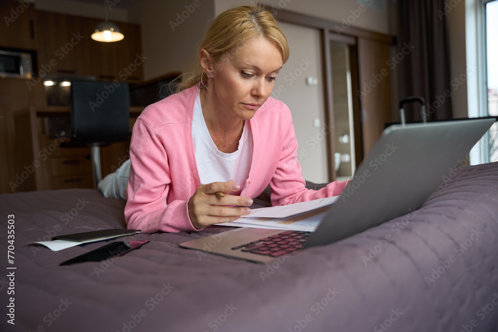 Focused freelancer dealing with business documentation in suite
