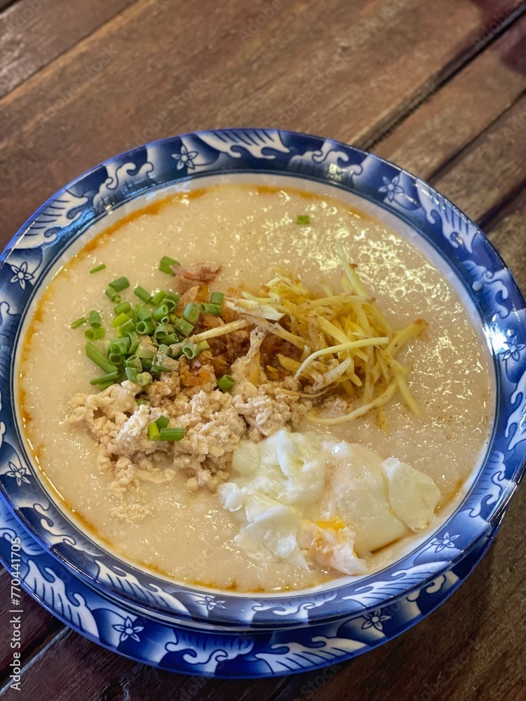 boiled rice clear soup with shrimp in a ceramic bowl on wooden table. homemade style food concept. boiled rice clear soup with shrimp in a ceramic bowl on wooden table. homemade style food concept.