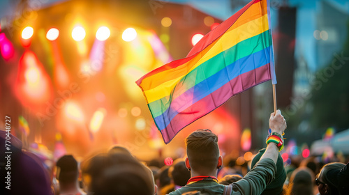 A man stands tall in the crowd at a concert, waving a rainbow flag proudly, focus on the rainbow flag flying high, Ai Generated Images