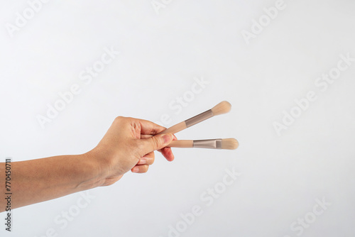 Cosmetic brushes in hand on white background. Set of makeup brushes