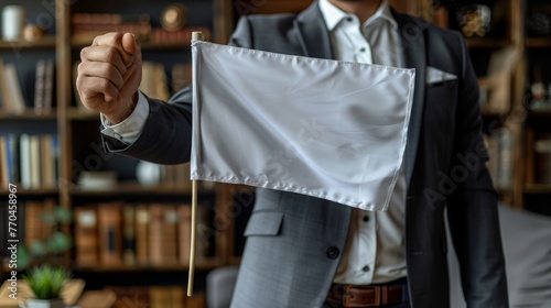  A man with a suit, tie, white flag, and bookcase