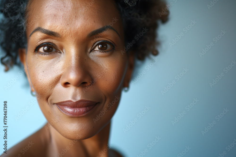 A woman with dark hair and a smile on her face. She has a lot of makeup on her face A woman with dark hair and a smile on her face. She has a lot of makeup on her face