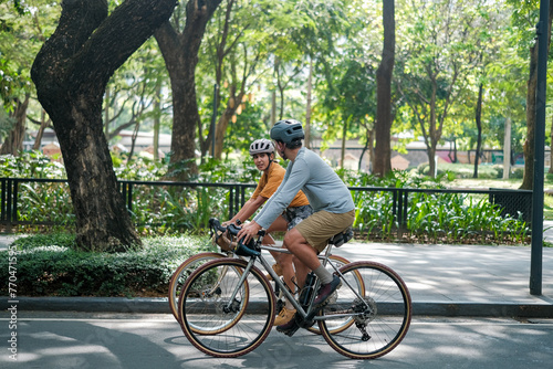 A young couple riding their bicycles in the summer.