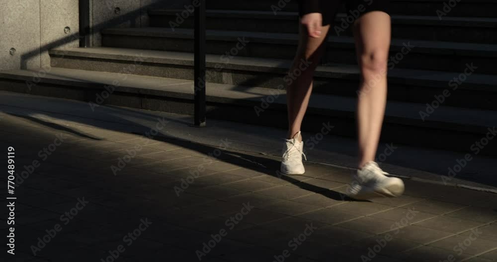Fit woman in her 40s embraces the day with a run through quiet city streets Fit woman in her 40s embraces the day with a run through quiet city streets
