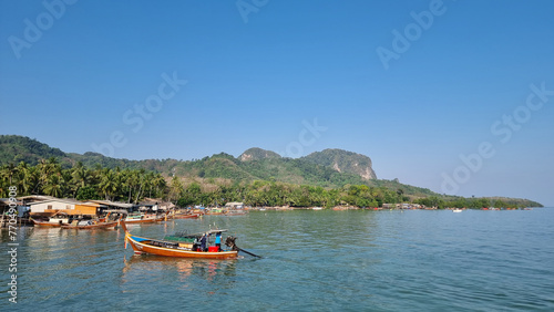A small boat peacefully floats atop the calm waters of a serene lake, reflecting the clear blue sky above