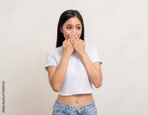 Oops. Shocked face asian woman while hands close mouth keep quiet. Can't speak no vote. Young latin female worried expression keep the secret. Attractive Asian woman standing on white background